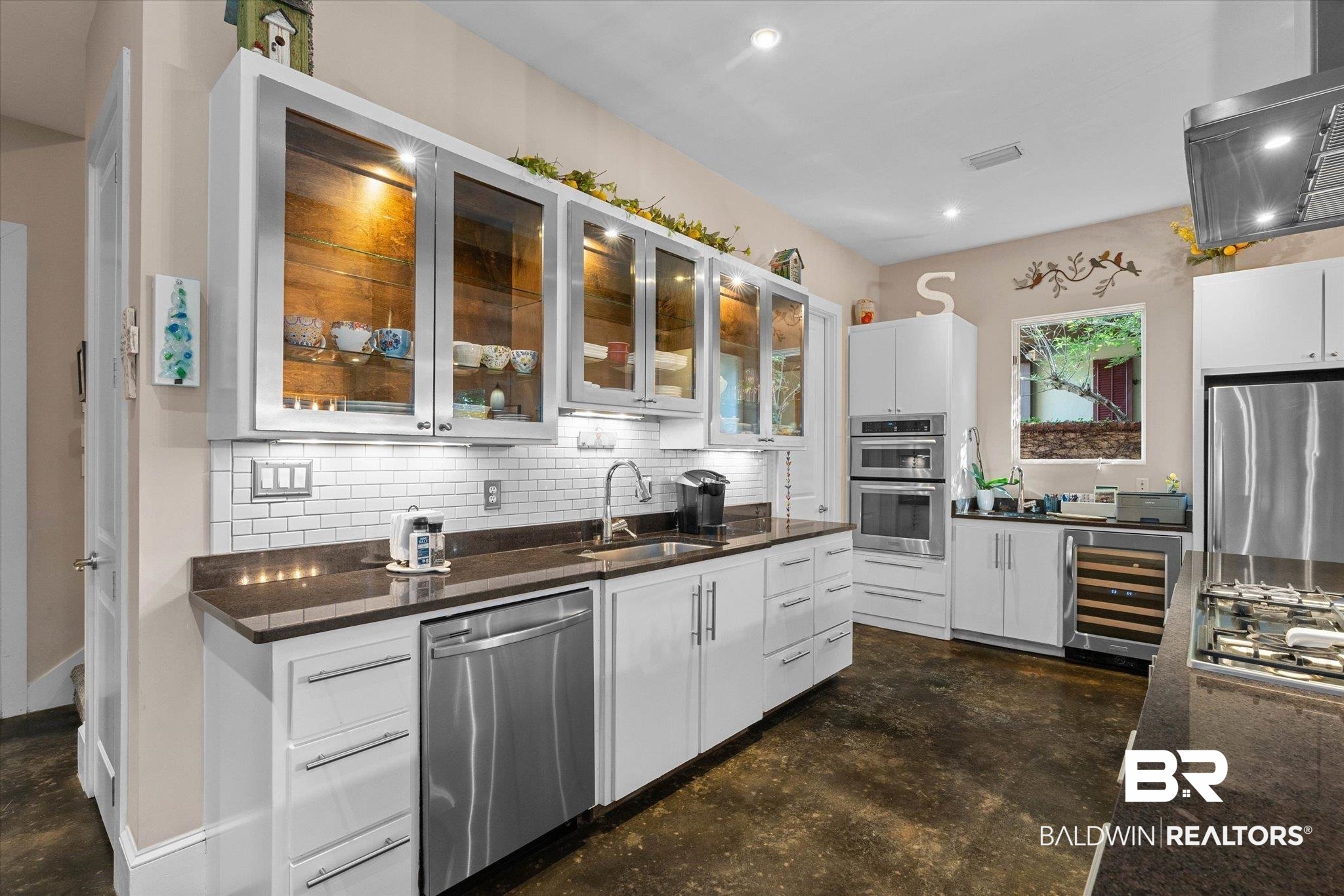 3400 Rue Royal Mobile, AL 36693 - Photo 12 of 33 Kitchen with appliances with stainless steel finishes, decorative backsplash, finished concrete floors, beverage cooler, and extractor fan