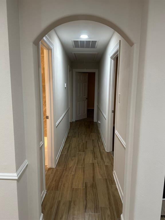 a view of a hallway with wooden floor and staircase