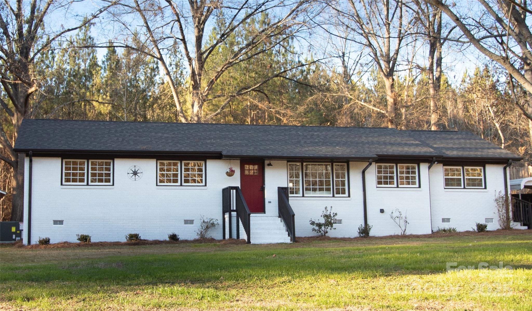 6726 Lockhart Road Sharon, SC 29742 - Photo 1 of 23 a view of a white house with a big yard and large trees