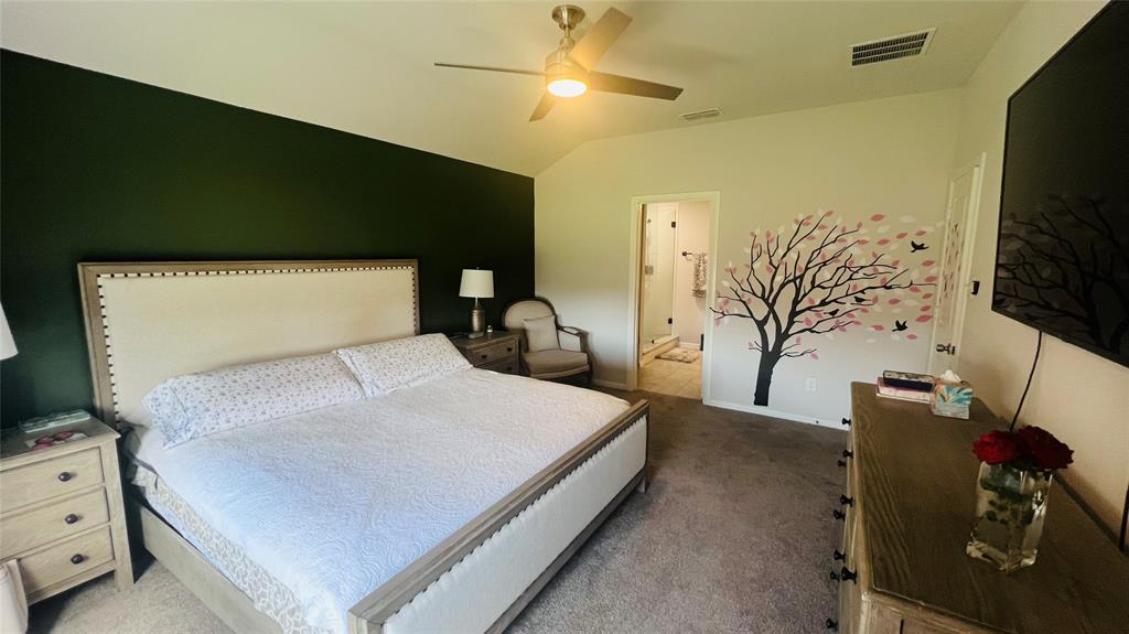 16729 Milwaukee Street Justin, TX 76247 - Photo 16 of 23 a bedroom with a bed and a flat tv screen on dresser