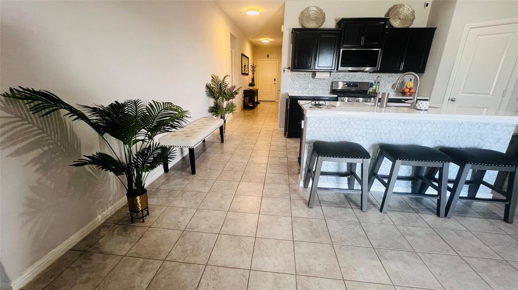 16729 Milwaukee Street Justin, TX 76247 - Photo 4 of 23 a kitchen with granite countertop a table chairs microwave and sink