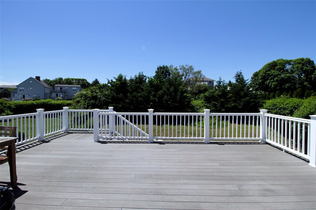 426 Tuckerman Avenue Middletown, RI 02842 - Photo 8 of 32 Outdoor storage under the stairs. Property line is just beyond the evergreens.