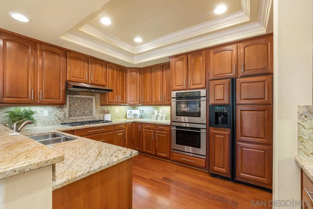 1329 Caminito Balada La Jolla, CA 92037 - Photo 7 of 31 a kitchen with kitchen island granite countertop wooden cabinets a stove and oven