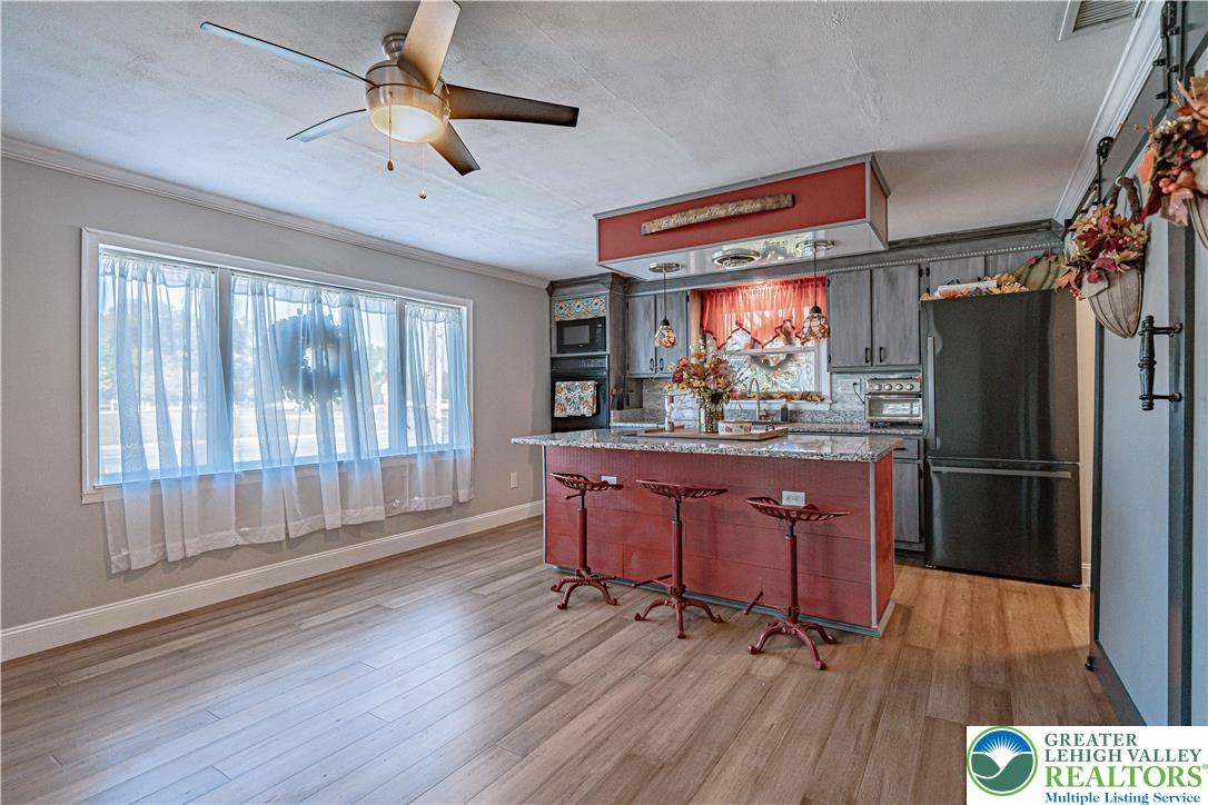 544 School Road Nazareth, PA 18064 - Photo 11 of 35 a kitchen with stainless steel appliances granite countertop a refrigerator a sink dishwasher a stove and white countertops with wooden floor