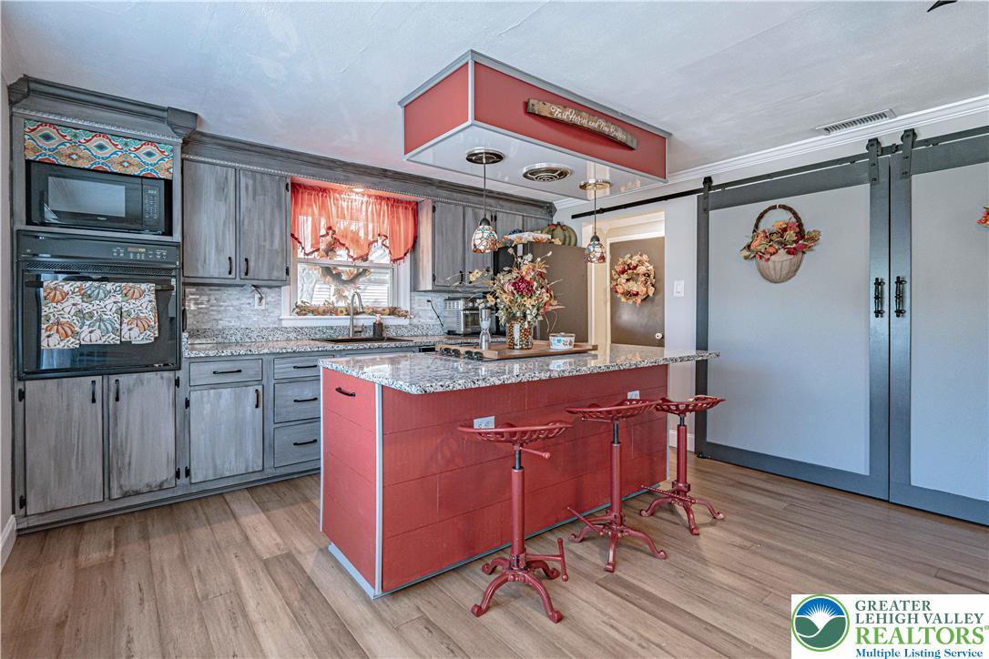 544 School Road Nazareth, PA 18064 - Photo 14 of 35 a kitchen with stainless steel appliances granite countertop a refrigerator a sink dishwasher a stove and white countertops with wooden floor