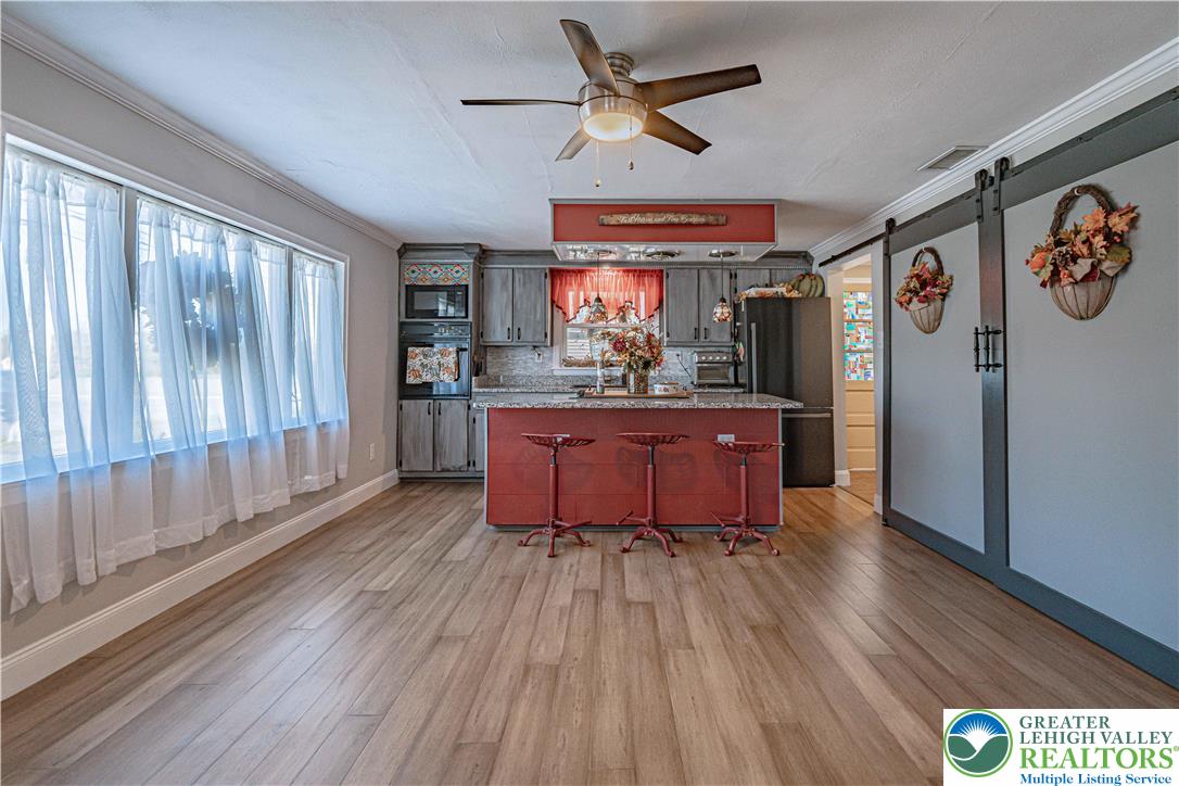 544 School Road Nazareth, PA 18064 - Photo 10 of 35 a living room with stainless steel appliances granite countertop a refrigerator a sink dishwasher a stove and white countertops with wooden floor