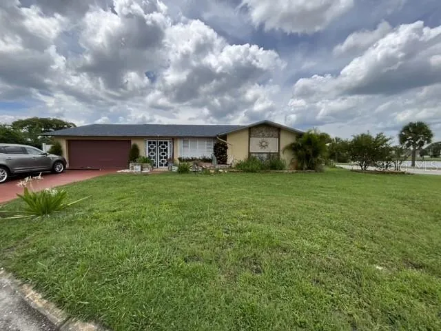 a view of a house with a big yard and large trees