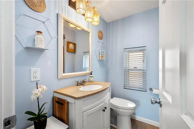 a bathroom with a sink and mirror with toilet