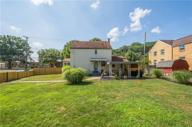 a view of a house with backyard and sitting area