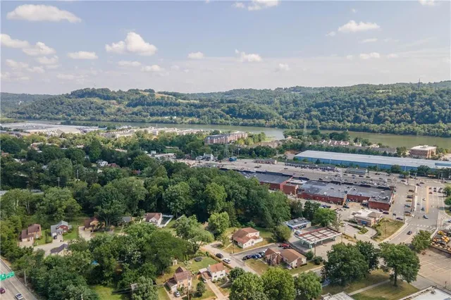 an aerial view of a city with lots of residential buildings ocean and mountain view in back