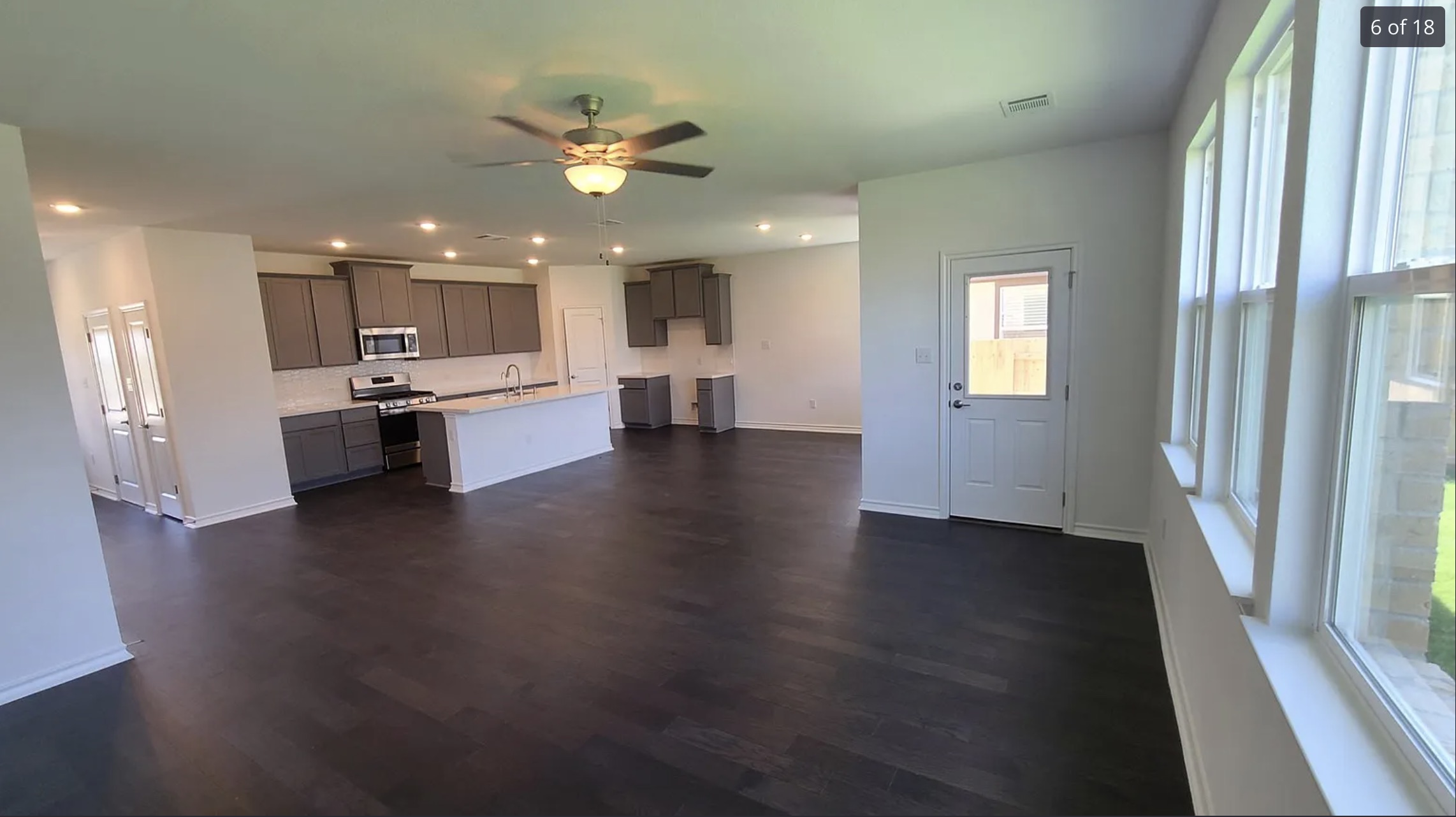 561 Pepperbark Loop Buda, TX 78610 - Photo 7 of 15 Kitchen featuring a ceiling fan, light countertops, stainless steel appliances, dark wood-style flooring, and gray cabinets