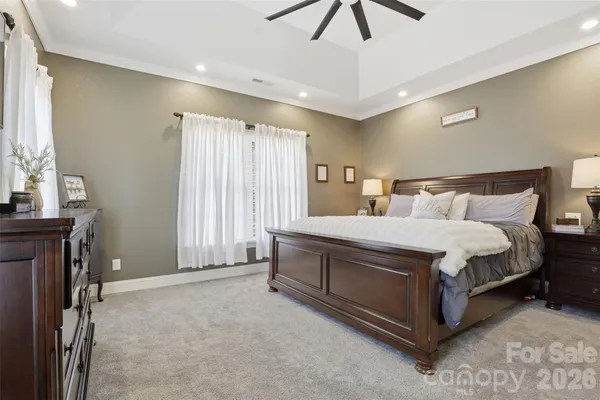 a spacious bedroom with a bed and a chandelier