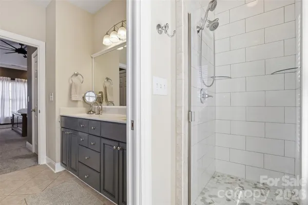 a bathroom with a granite countertop sink a mirror and shower