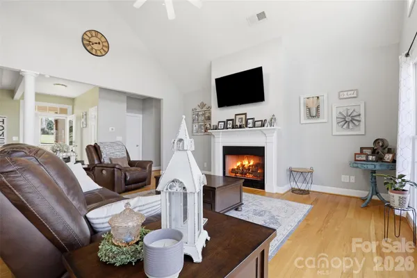 a living room with furniture a flat screen tv and a fireplace
