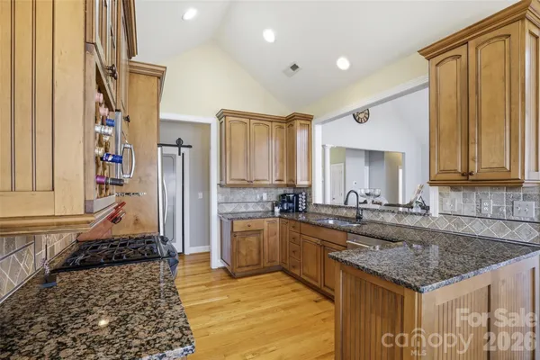 a kitchen with stainless steel appliances granite countertop a sink stove and refrigerator