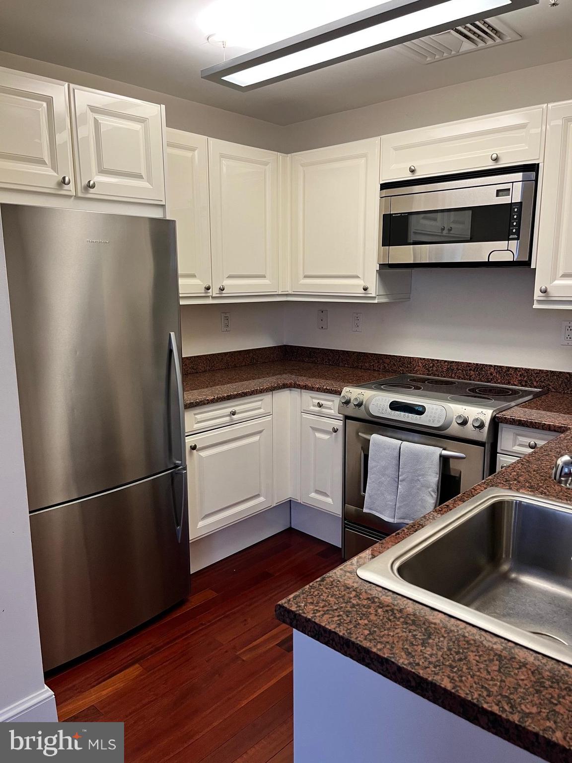 1500 Chestnut Street, Unit 15I Philadelphia, PA 19102 - Photo 1 of 18 a kitchen with granite countertop a refrigerator sink and cabinets