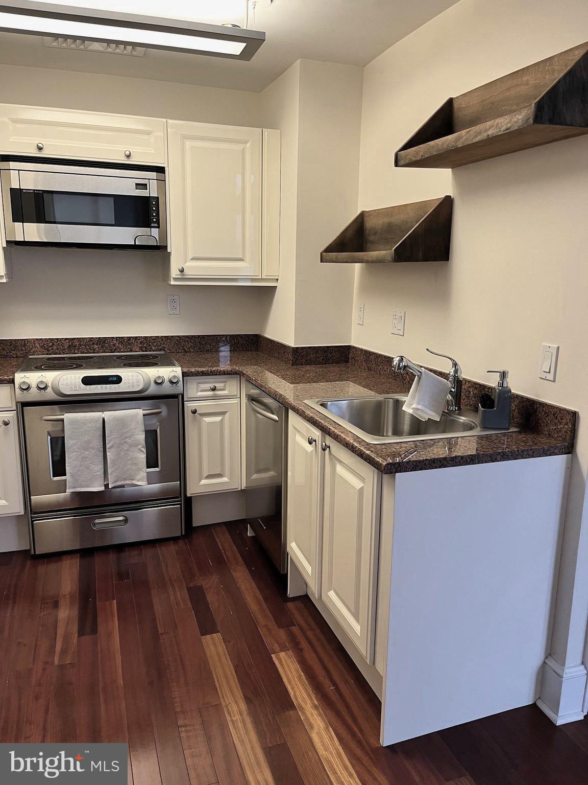 1500 Chestnut Street, Unit 15I Philadelphia, PA 19102 - Photo 2 of 18 a kitchen with granite countertop a stove and a wooden floor