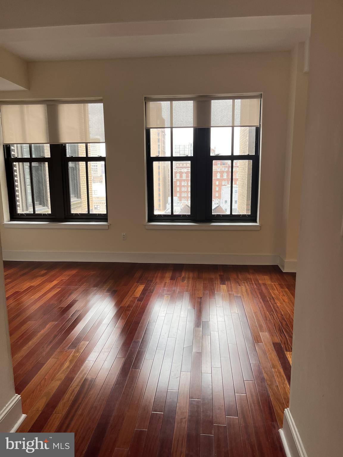 1500 Chestnut Street, Unit 15I Philadelphia, PA 19102 - Photo 3 of 18 an empty room with wooden floor and windows