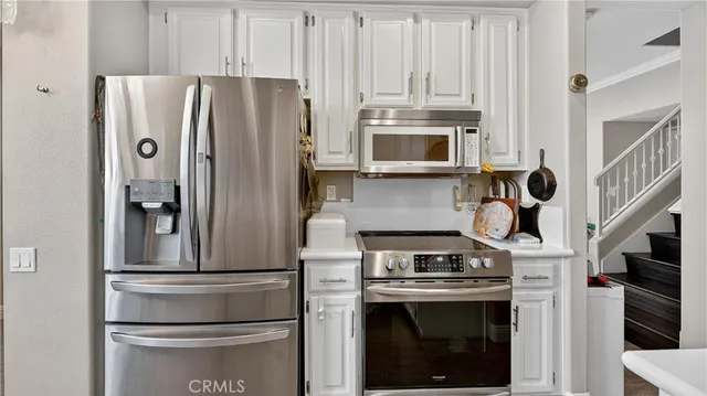 a kitchen with stainless steel appliances granite countertop a refrigerator and a stove top oven