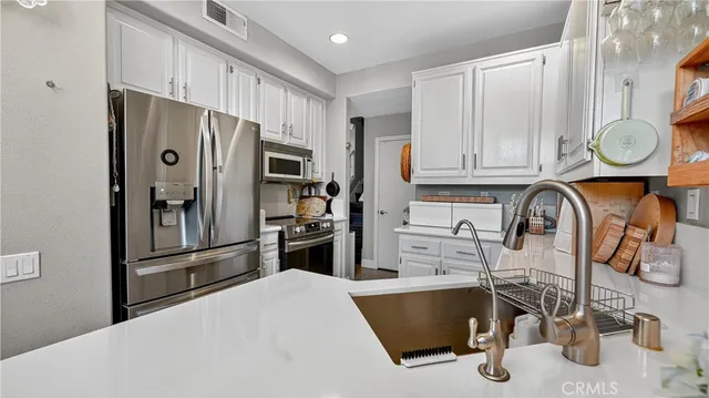 a kitchen with stainless steel appliances granite countertop a refrigerator and a stove top oven