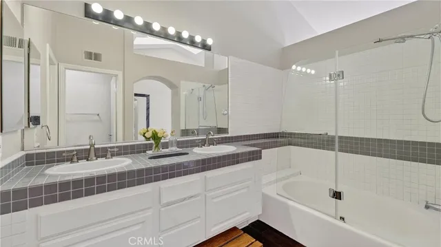 a bathroom with a tub sink and mirror