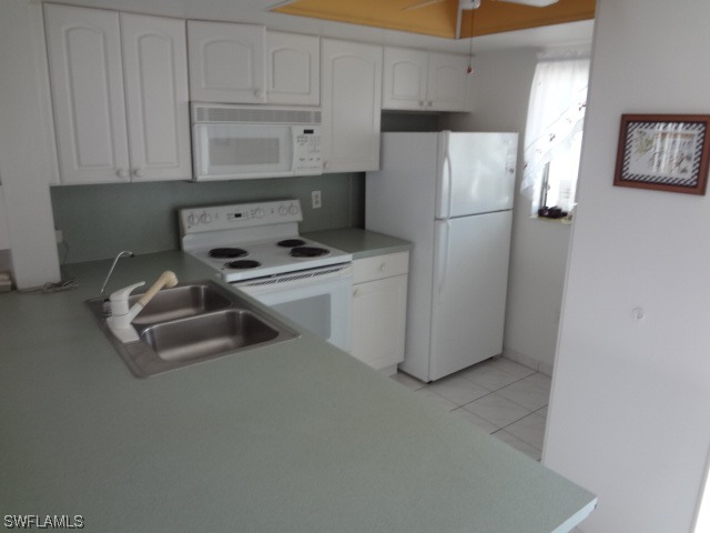 25225 Rampart Boulevard Punta Gorda, FL 33983 - Photo 4 of 7 a kitchen with refrigerator a stove a sink and cabinets