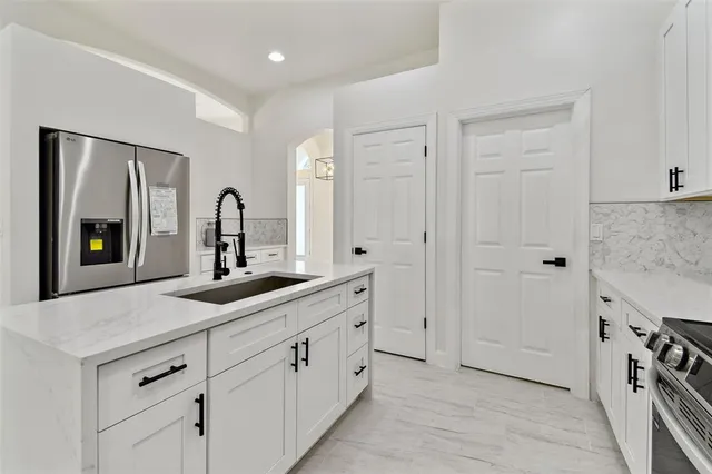 a kitchen with a sink a stove and cabinets