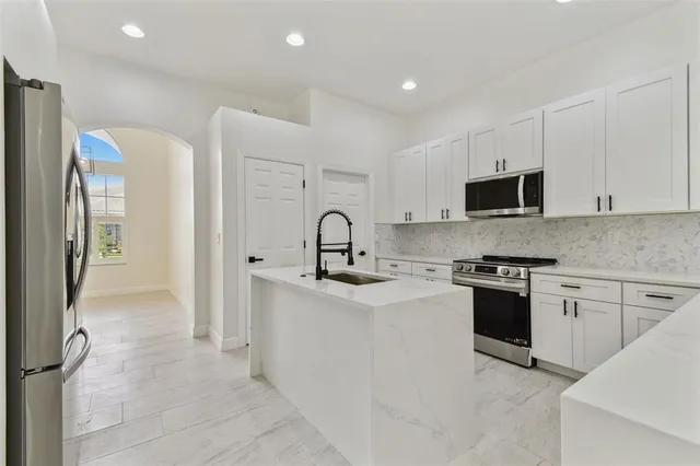 a kitchen with white cabinets and refrigerator