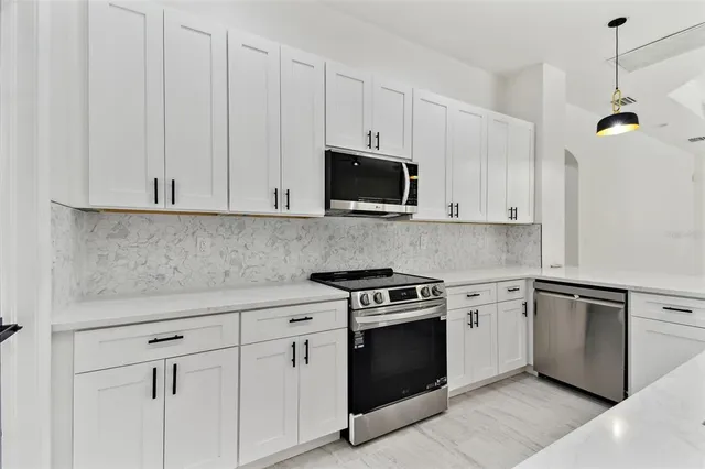 an empty room with windows and ceiling fan