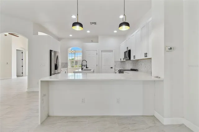 a view of a livingroom with a ceiling fan a ceiling fan and wooden floor