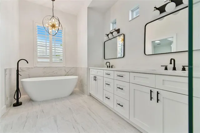 a view of a house with a yard plants and large tree