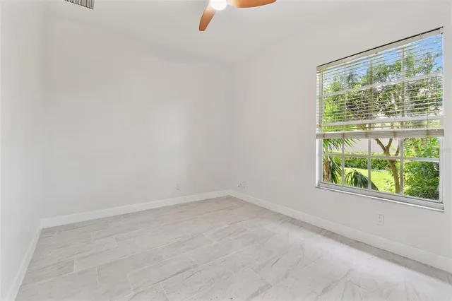 an aerial view of residential houses with outdoor space and trees