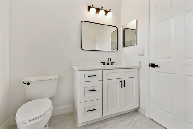 an aerial view of residential houses with outdoor space and trees