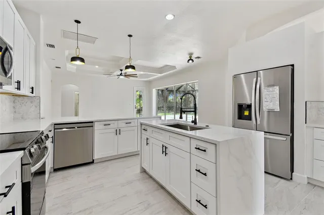 a kitchen with stainless steel appliances granite countertop a sink and cabinets