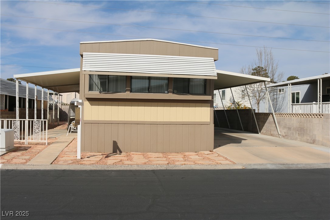 4633 Royal Ridge Boulevard Las Vegas, NV 89103 - Photo 1 of 13 Manufactured / mobile home featuring an attached carport, driveway, and fence