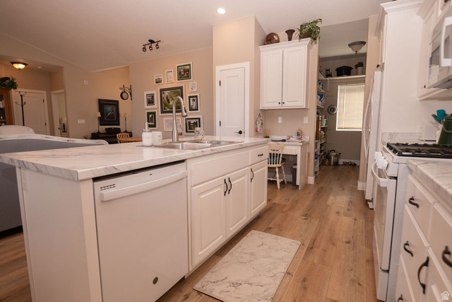 745 East 885 North Beaver, UT 84713 - Photo 16 of 50 Kitchen with white cabinetry, white appliances, an island with sink, light wood finished floors, and vaulted ceiling