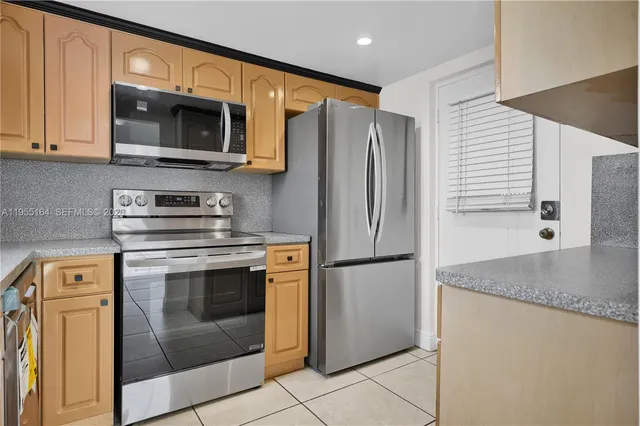 a kitchen with stainless steel appliances granite countertop a refrigerator stove and microwave