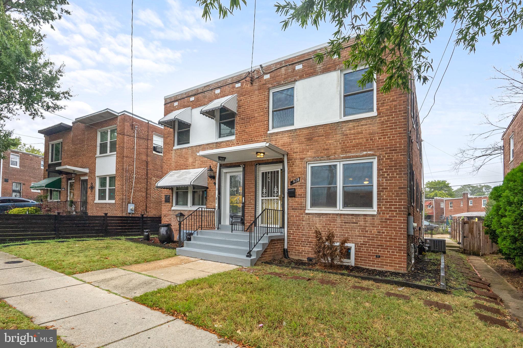 518 Riggs Road Northeast Washington, DC 20011 - Photo 17 of 18 a view of a brick house with many windows plants and large tree