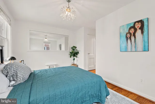 a bedroom with a large bed and a chandelier