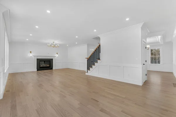 a view of a livingroom with a fireplace a ceiling fan and windows
