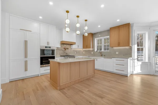 a large kitchen with kitchen island a sink stainless steel appliances and cabinets