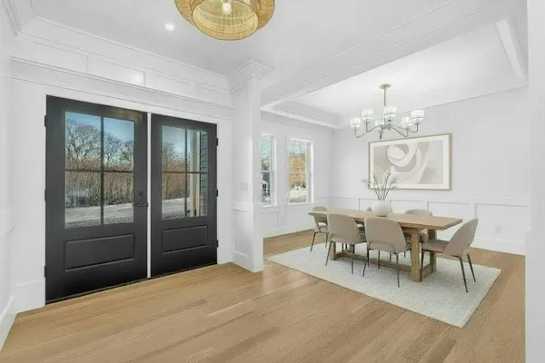 a dining room with wooden floor and a chandelier