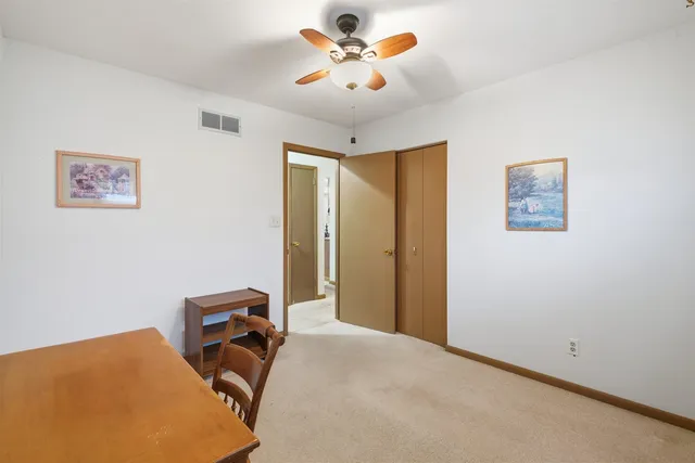 a view of a workspace with furniture and a ceiling fan