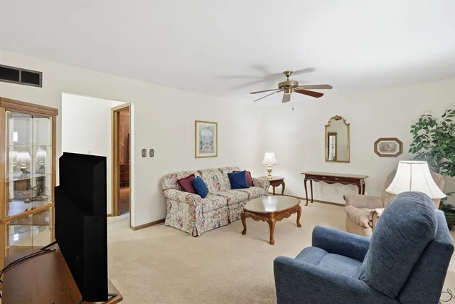 a living room with furniture a ceiling fan and a rug