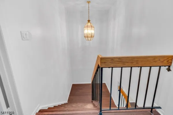 a view of staircase with railing and white walls