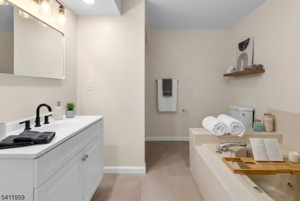 a bathroom with a bathtub sink mirror and vanity