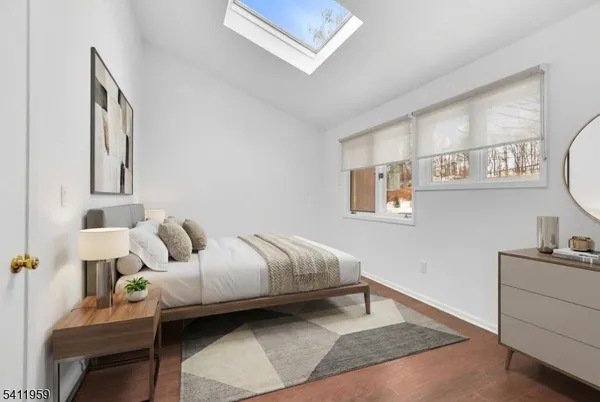a bedroom with a bed wooden floor and window