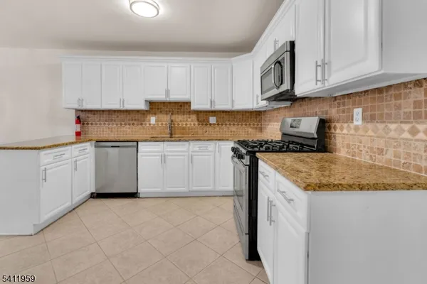 a kitchen with stainless steel appliances granite countertop a sink stove and cabinets