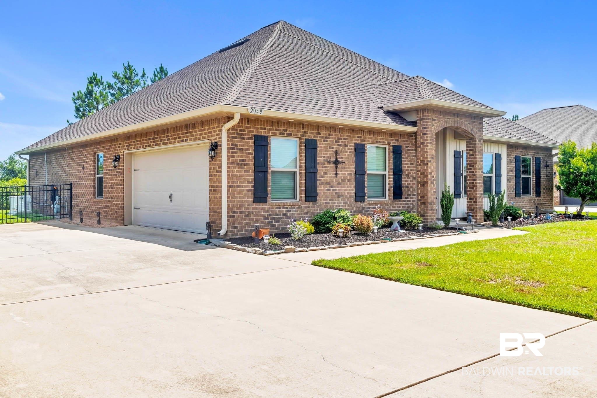 2049 Bourbon Street Foley, AL 36535 - Photo 6 of 56 View of front facade featuring brick siding, a garage, roof with shingles, and concrete driveway