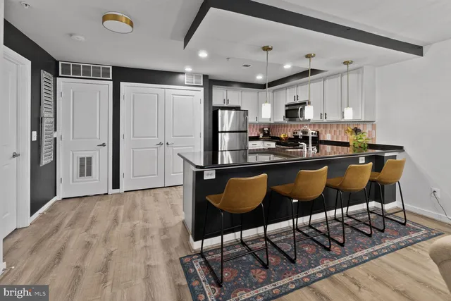 a kitchen with stainless steel appliances granite countertop a refrigerator and a stove top oven